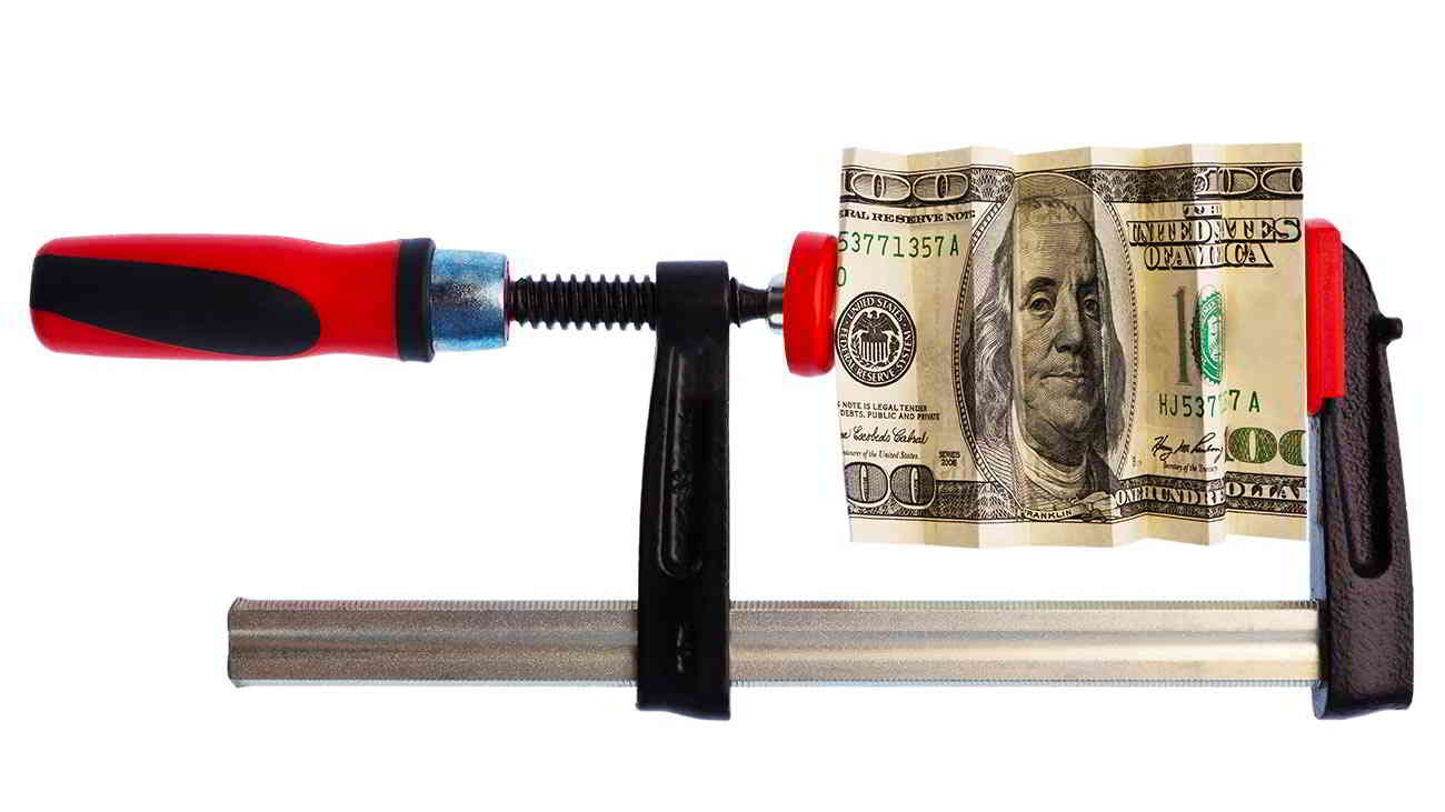 hundred dollar bill squeezed in vise