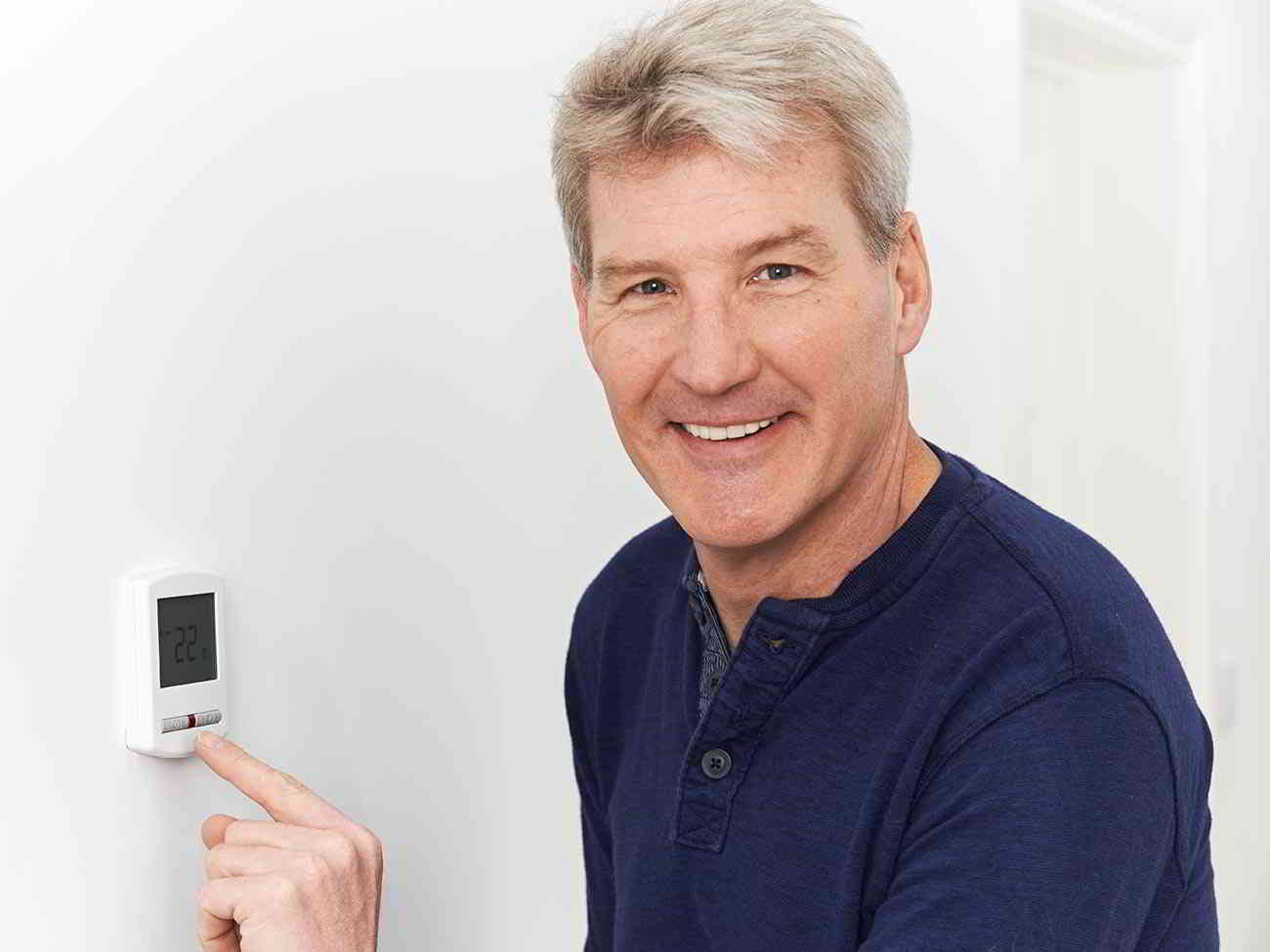 man programming thermostat