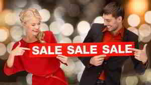 couple holding holiday sale sign
