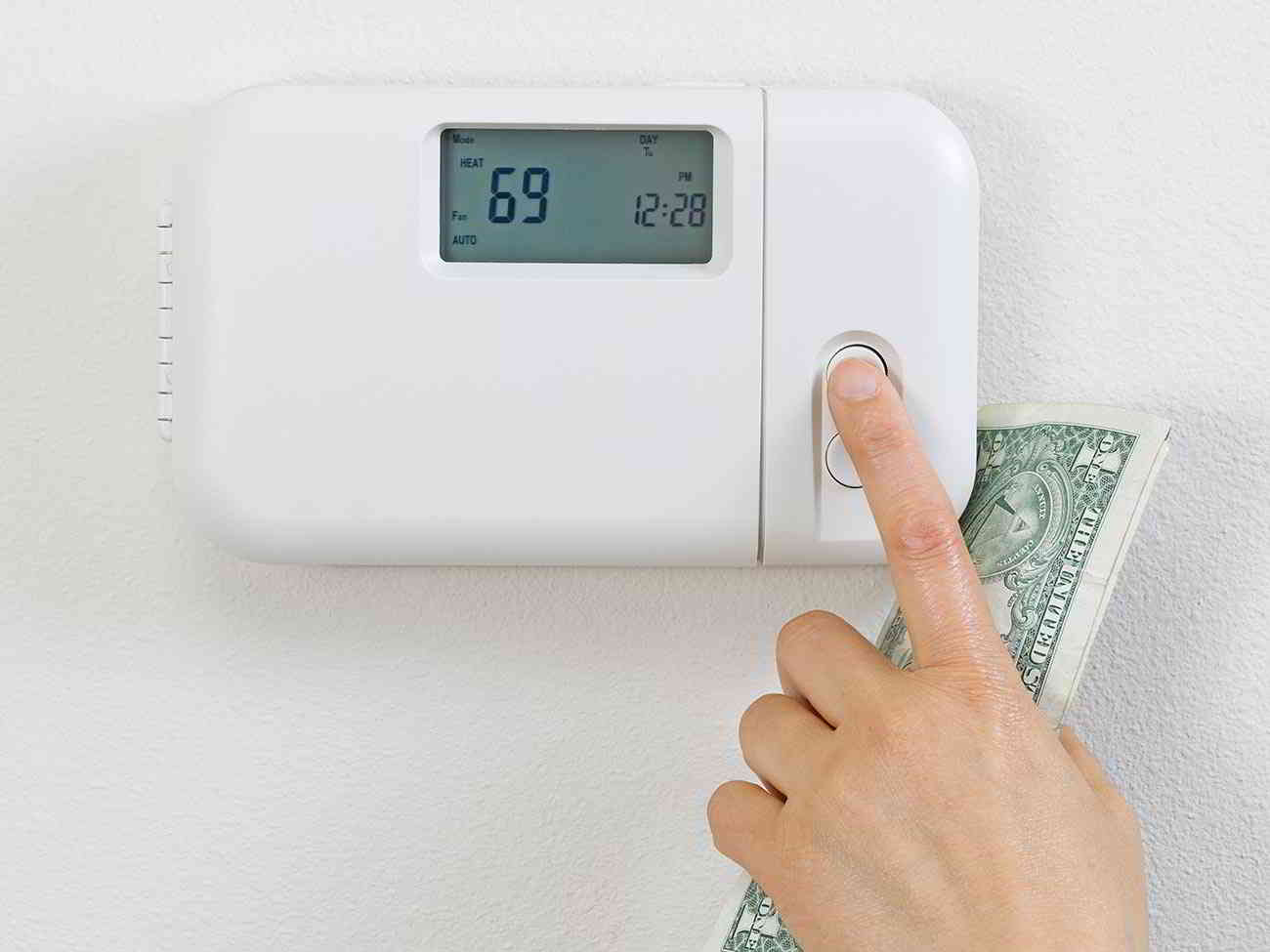 person lowering thermostat setting