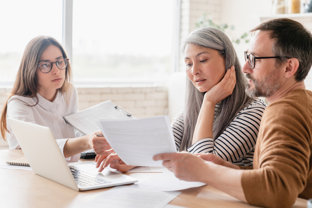 A couple talks to a debt management counselor about their various debt relief options, including debt consolidation