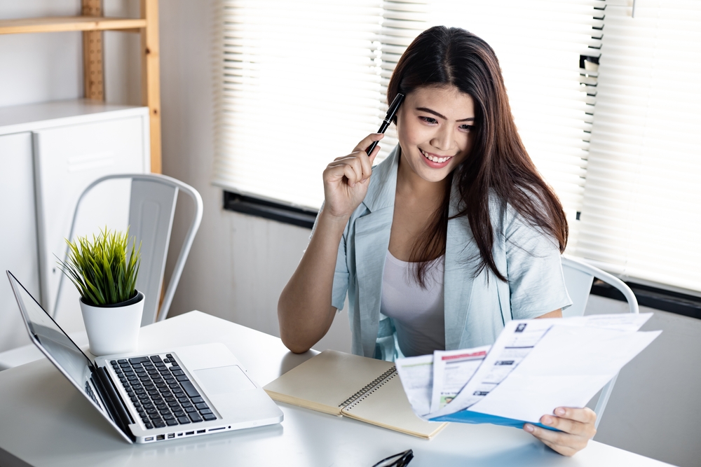 A young woman looks at her credit card bills as she prepares to consolidate her debt using a debt consolidation personal loan