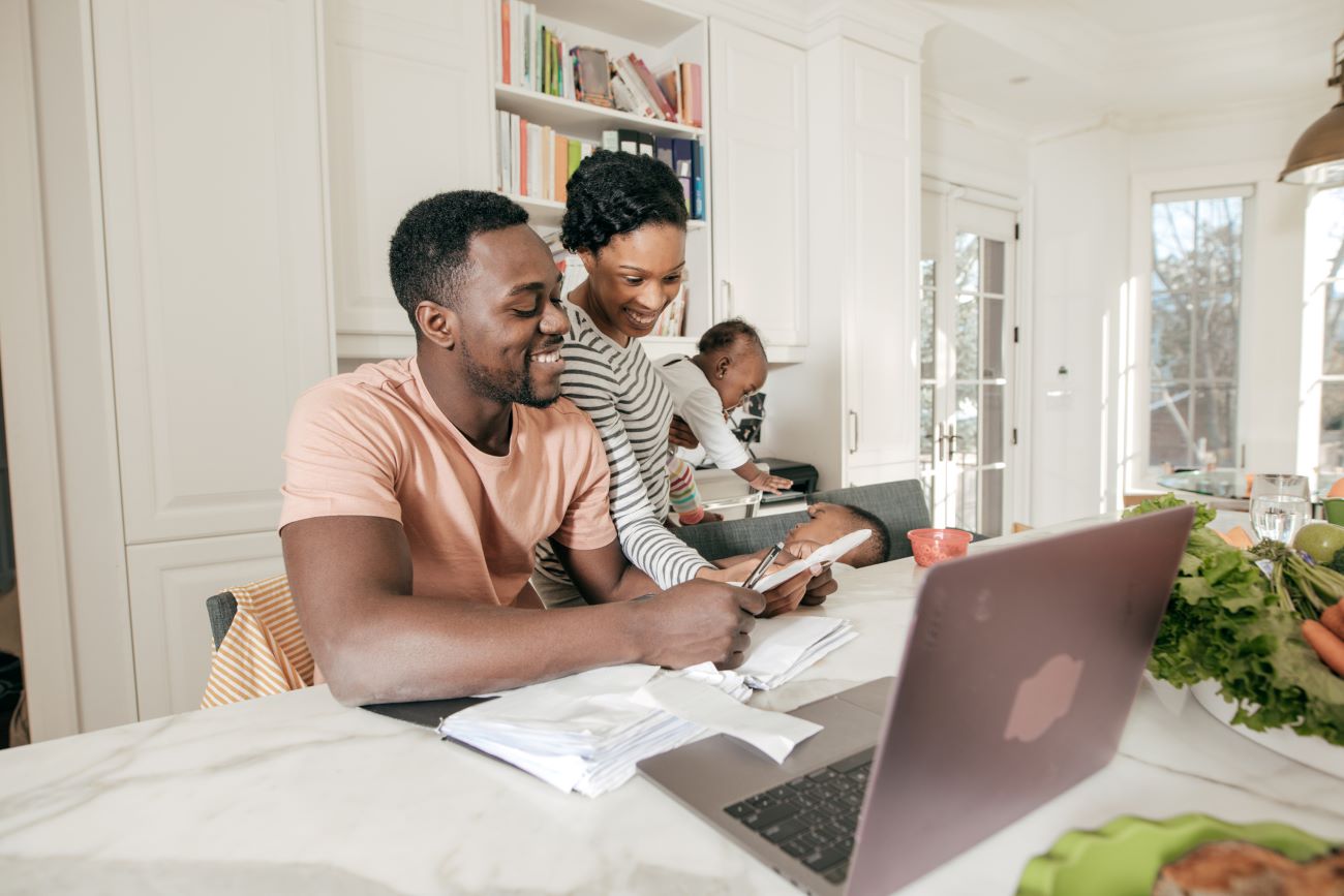 A couple works on their budget while their children play in the background