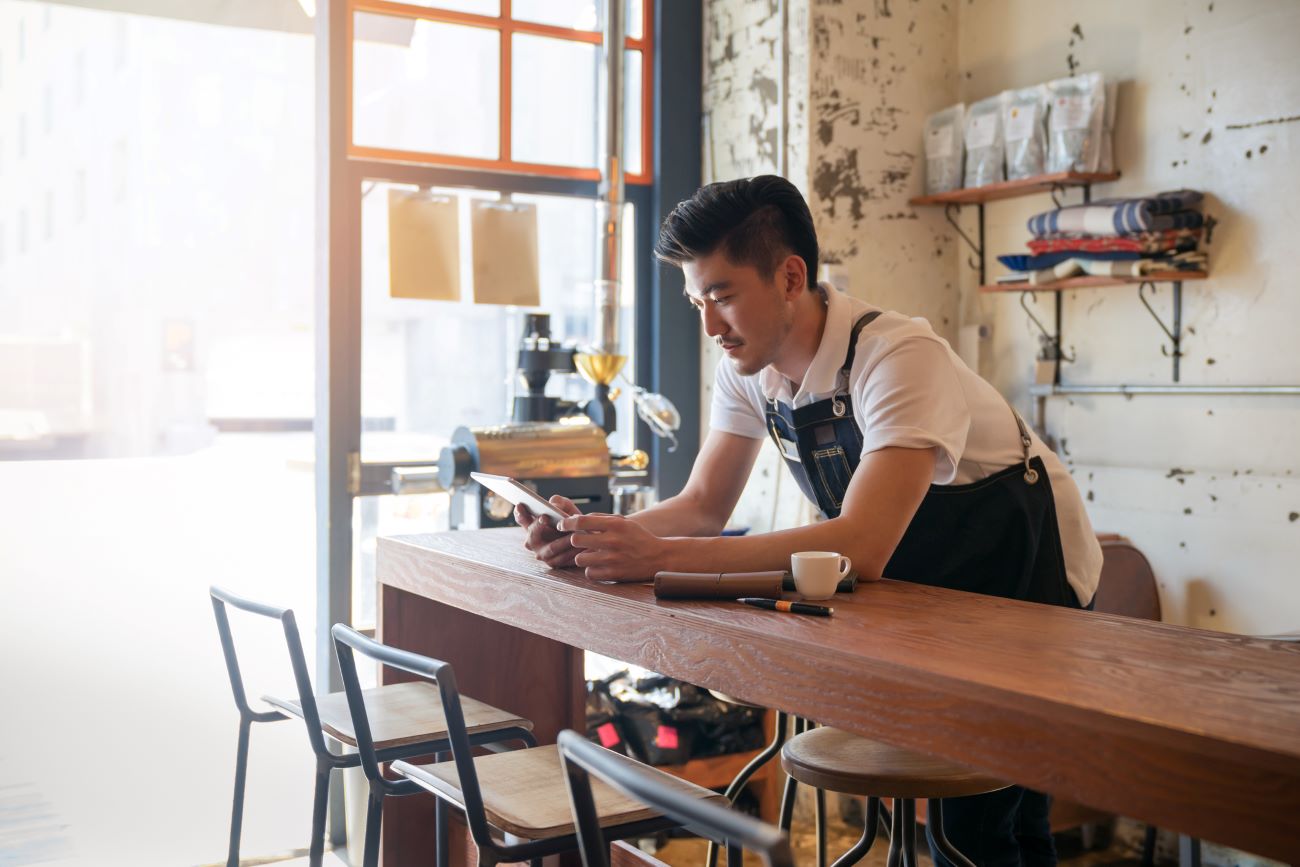 a small business owner uses his tablet to look for business credit cards