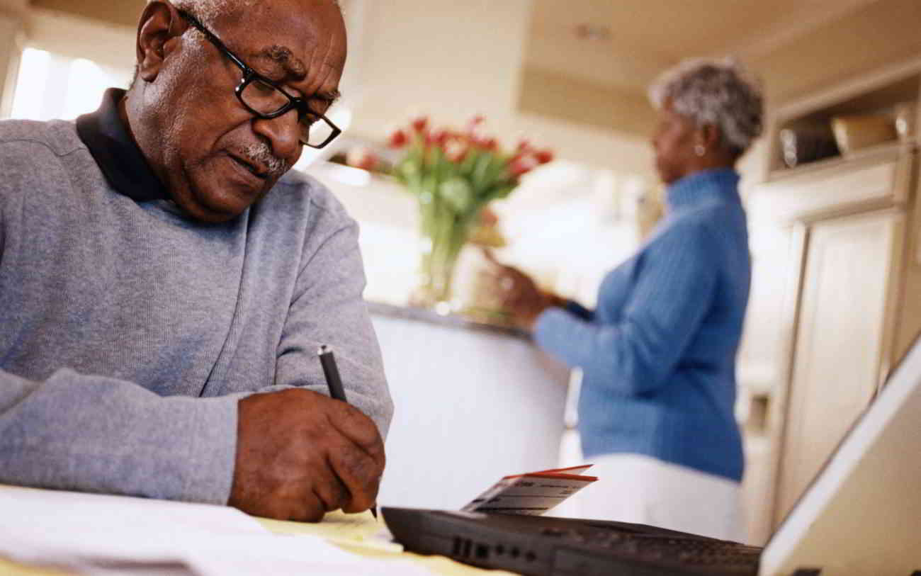 A man and his partner discuss applying for a loan and work on their finances