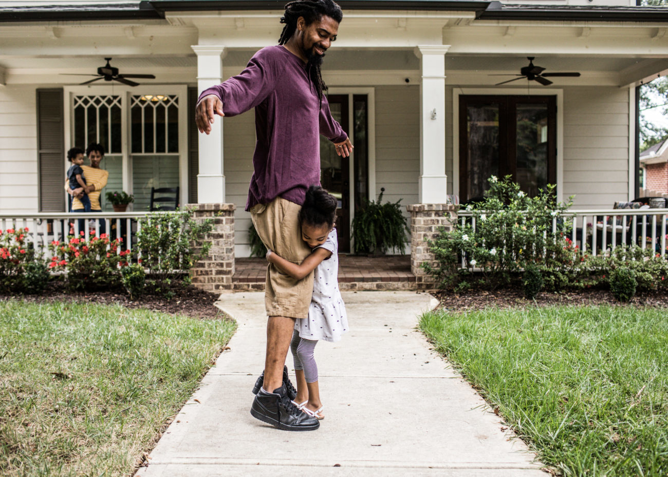 Portrait of father and daughter in front of home