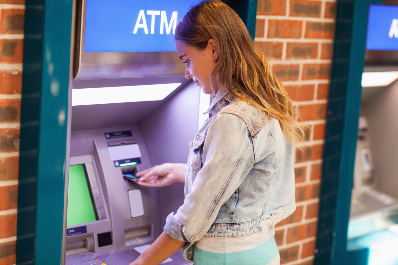 A woman uses the ATM to withdraw money
