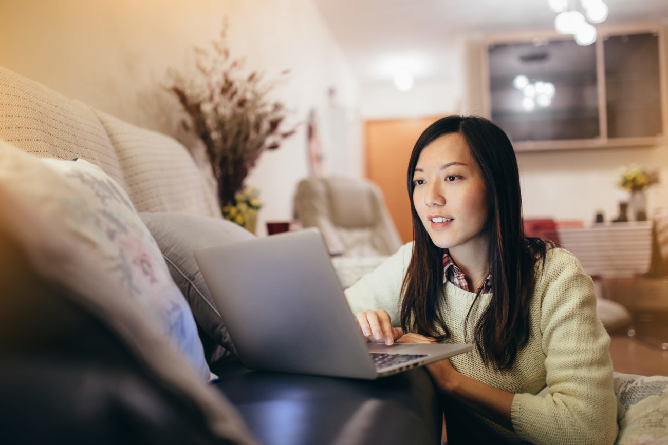 A woman uses her laptop computer to check her credit score.