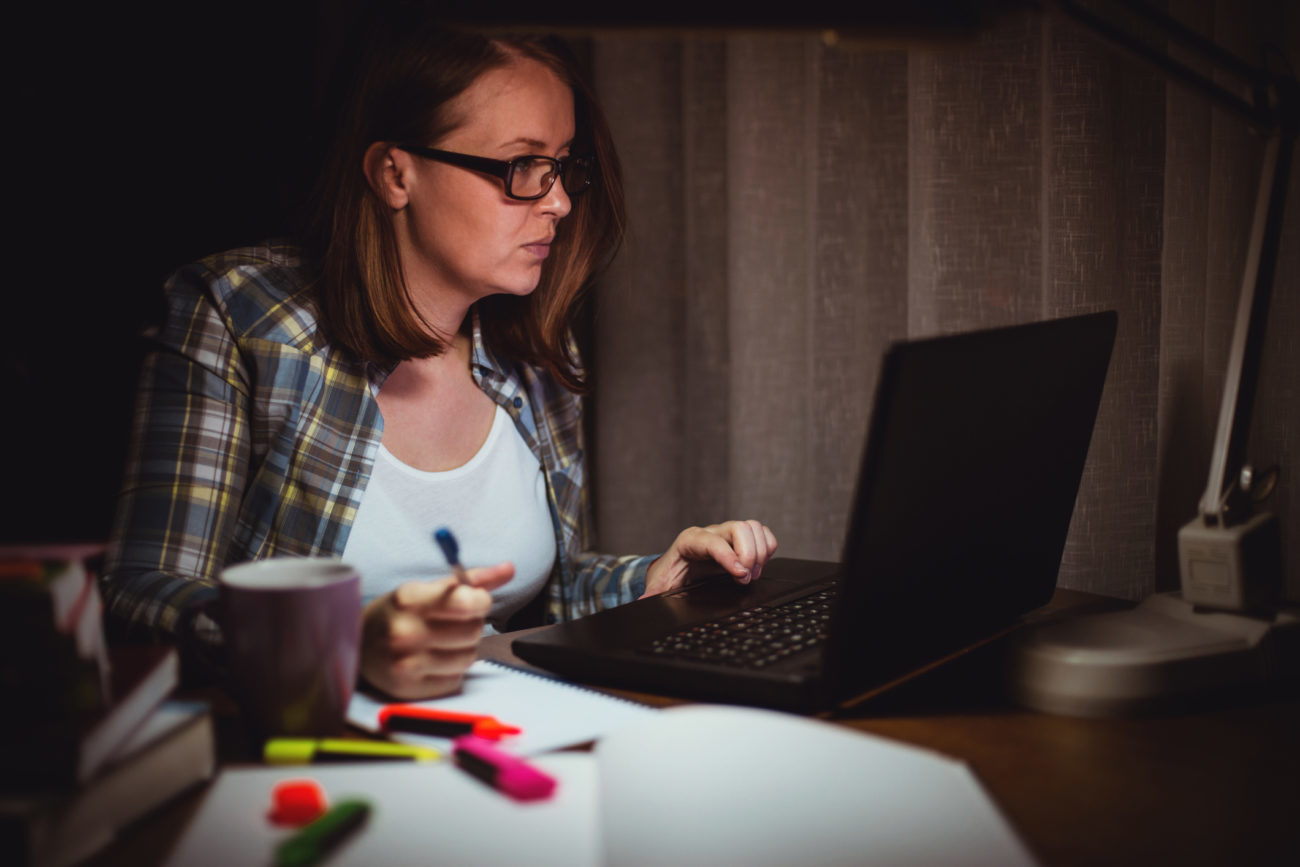 A woman searches for a personal loan on her computer late at night.