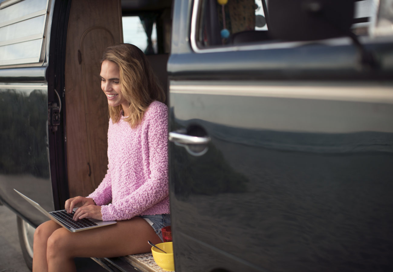 A woman uses her computer to apply for a LendingPoint personal loan as she sits in her van