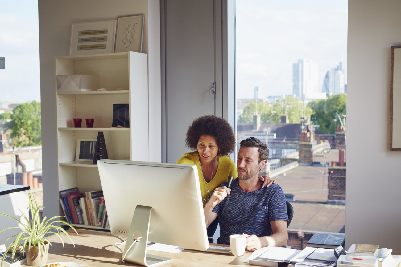 A couple at home look at their computer as they consider debt consolidation.