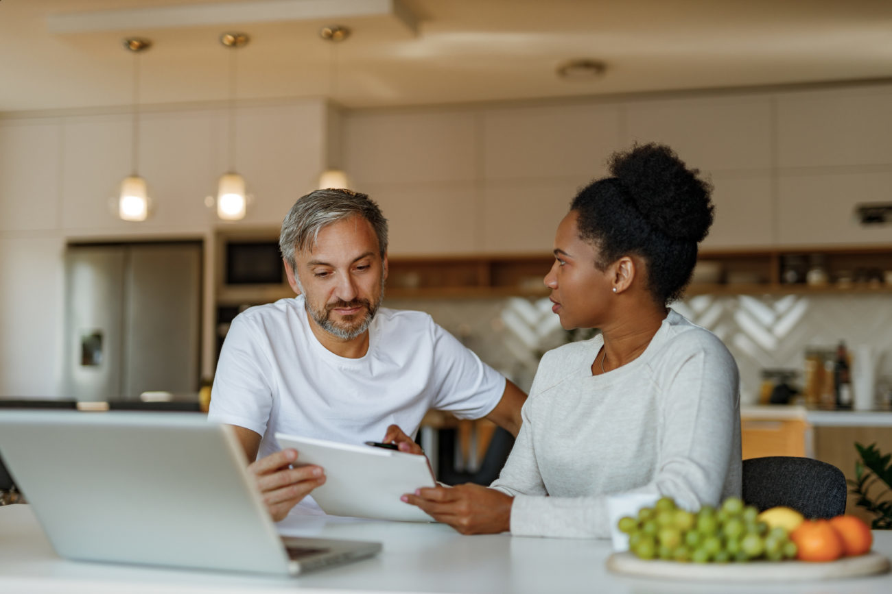 Married people having a discussion about personal loan rates while sitting in front of a computer at home