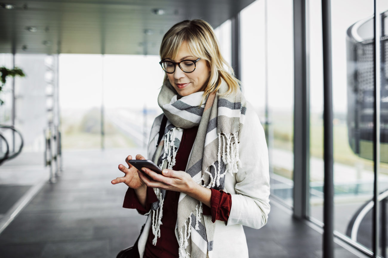 A woman uses her phone to manage her autopay personal loan payments.