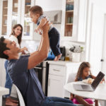 A family enjoys spending time together in the kitchen of the new home they've just purchased