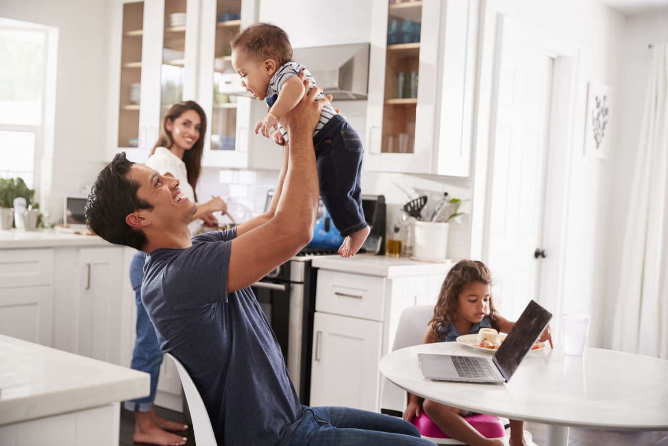 A family enjoys spending time together in the kitchen of the new home they've just purchased