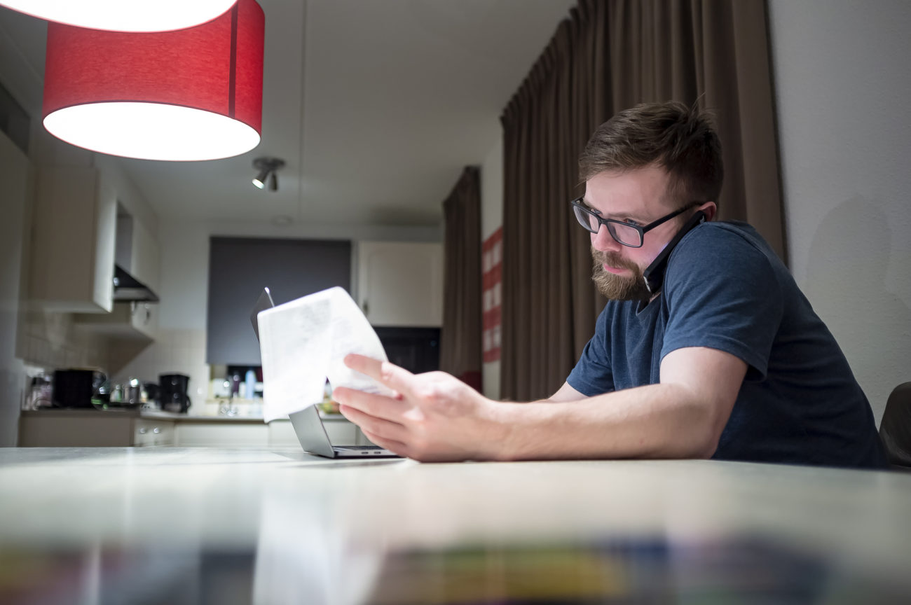 a man manages his finances from his laptop