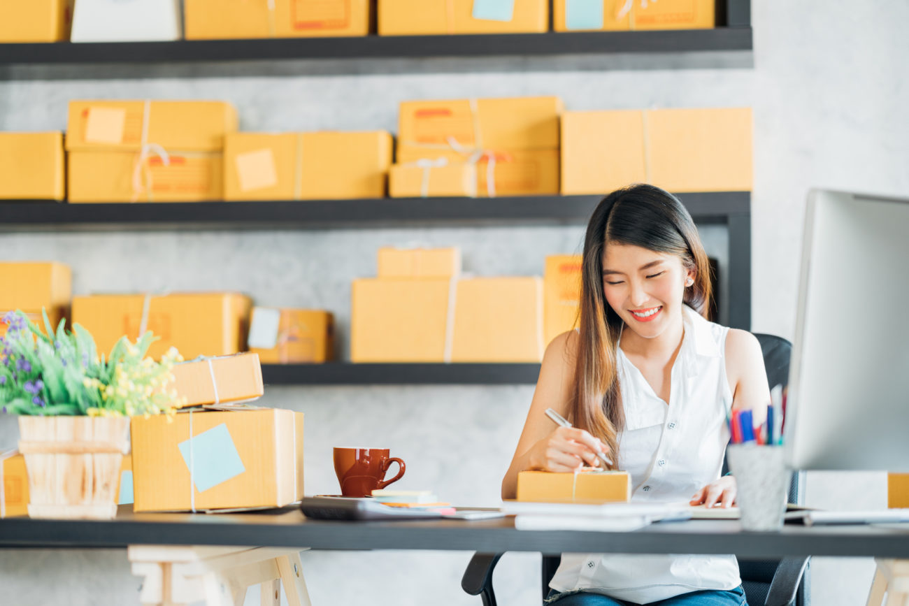 A young entrepreneur sit at a desk while working at her small business