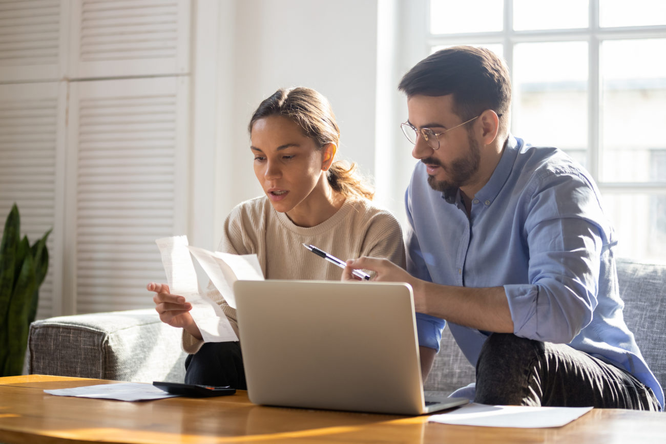 Young couple sits in front of computer while paying their bills online