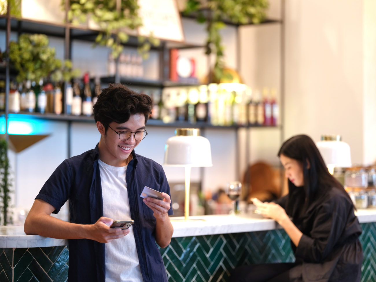 A young man uses his mobile phone to apply for a personal loan