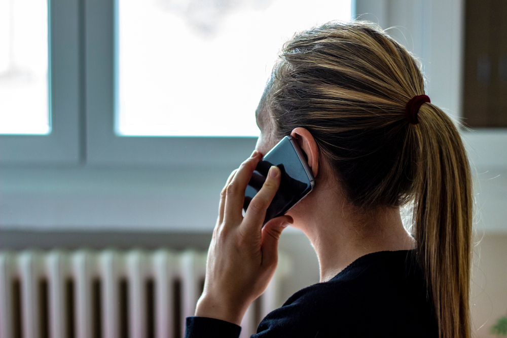 A worried woman talks on phone about emergency loan