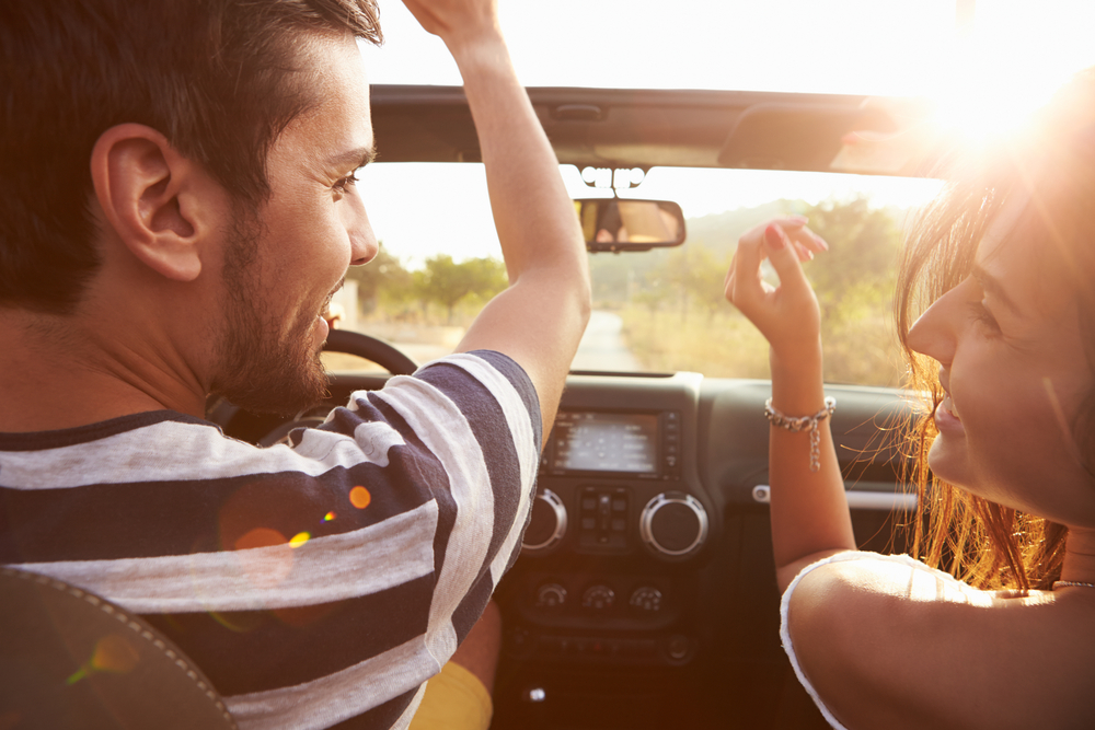 A young couple enjoy their new car